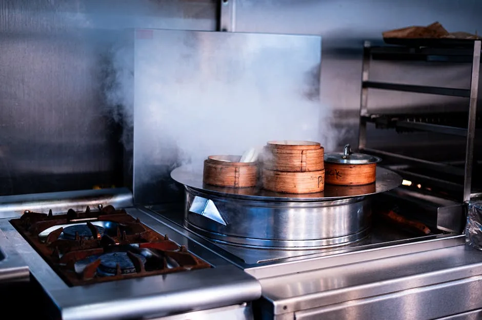 Steam rising in commercial kitchen showing why exhaust fan cleaning matters