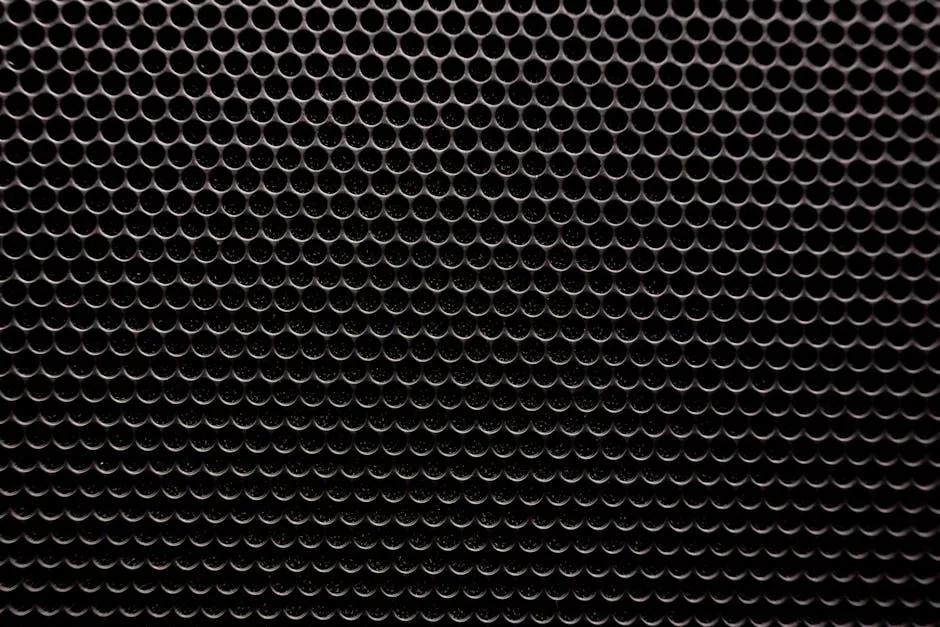 Close-up of a metallic grille with a uniform circular pattern — similar to baffle filter construction